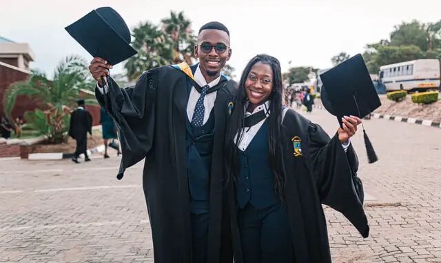 Two students wearing graduation gown